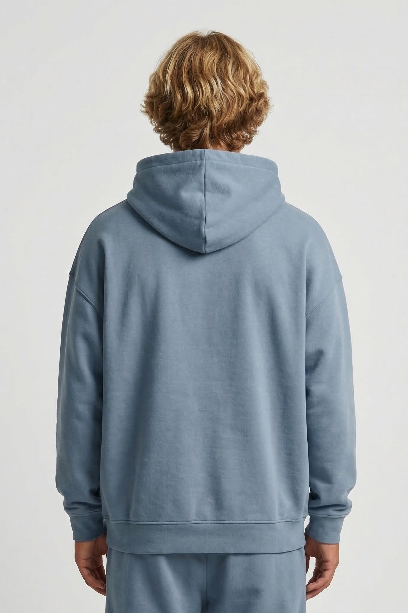 Person wearing a blue tracksuit with a plain background