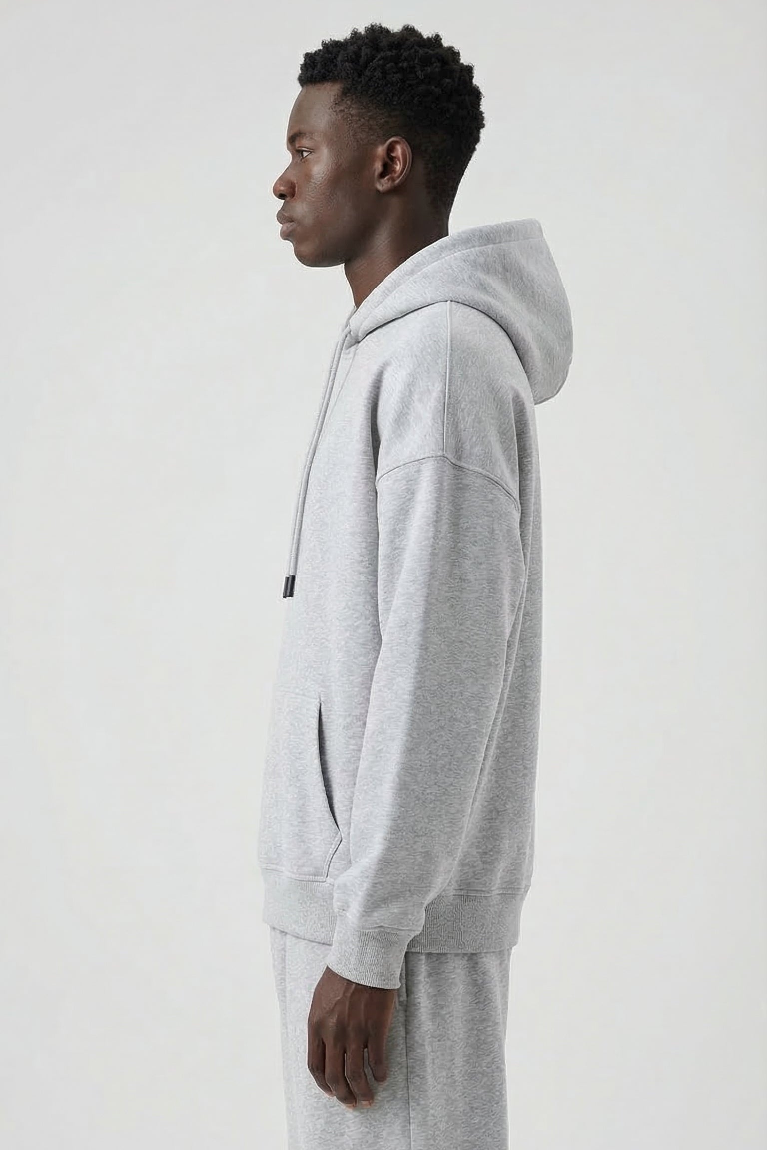 Person wearing a gray hoodie and pants on a white background