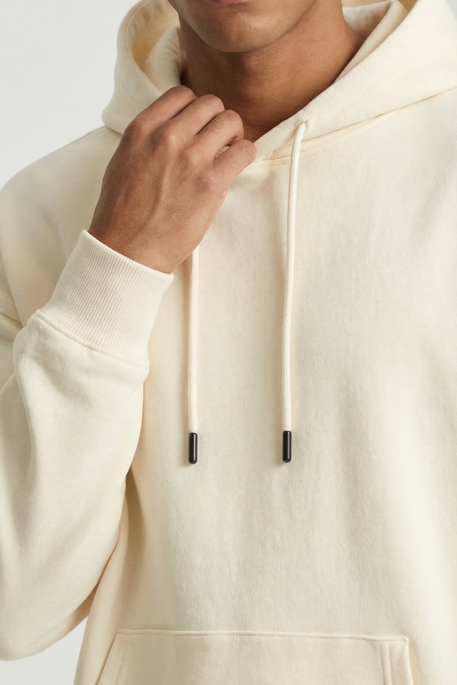 Man wearing a beige hoodie against a white background