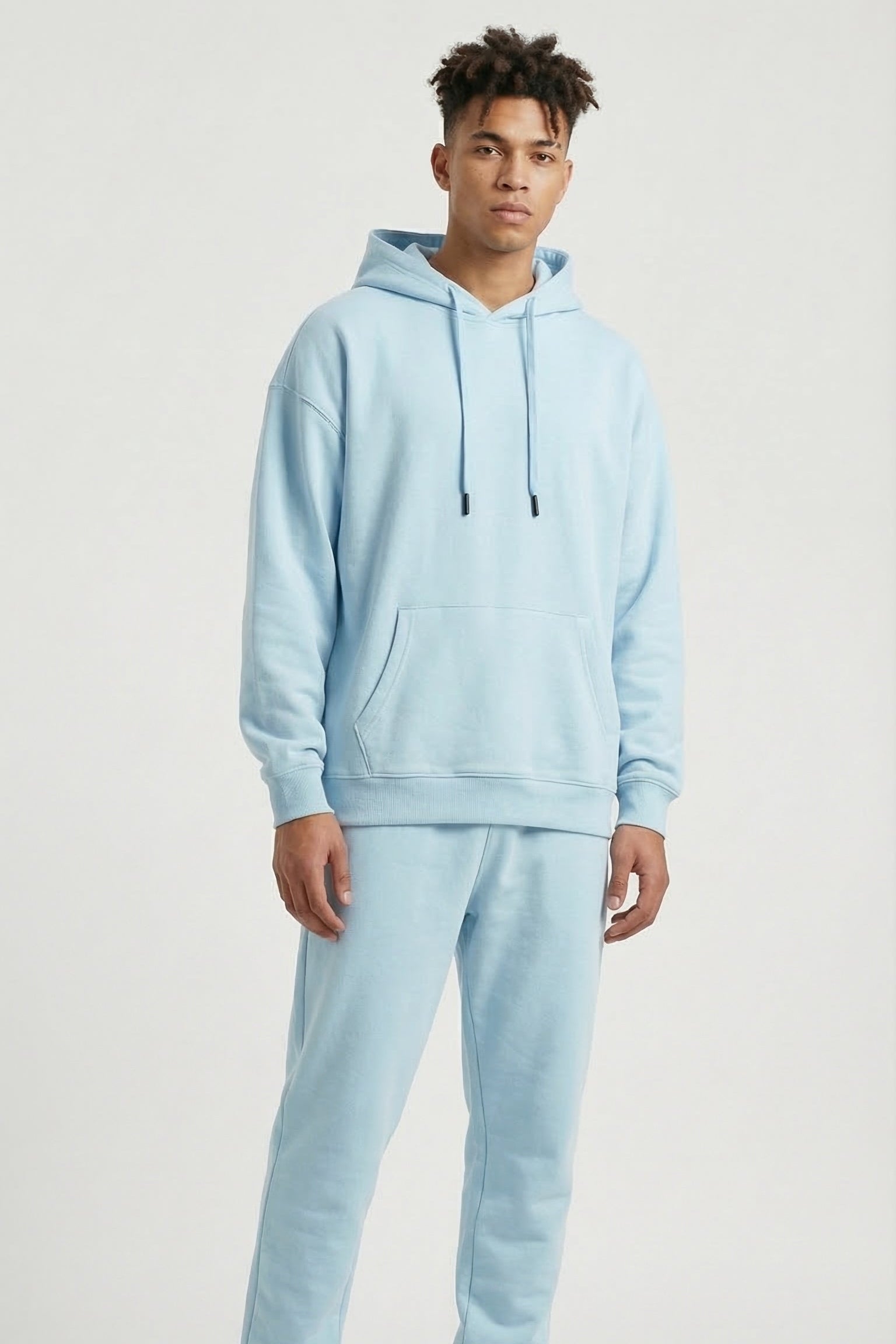 Person wearing a light blue tracksuit on a white background