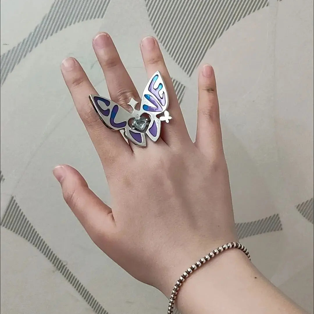 Blue enamel butterfly ring with heart crystal on finger and silver band