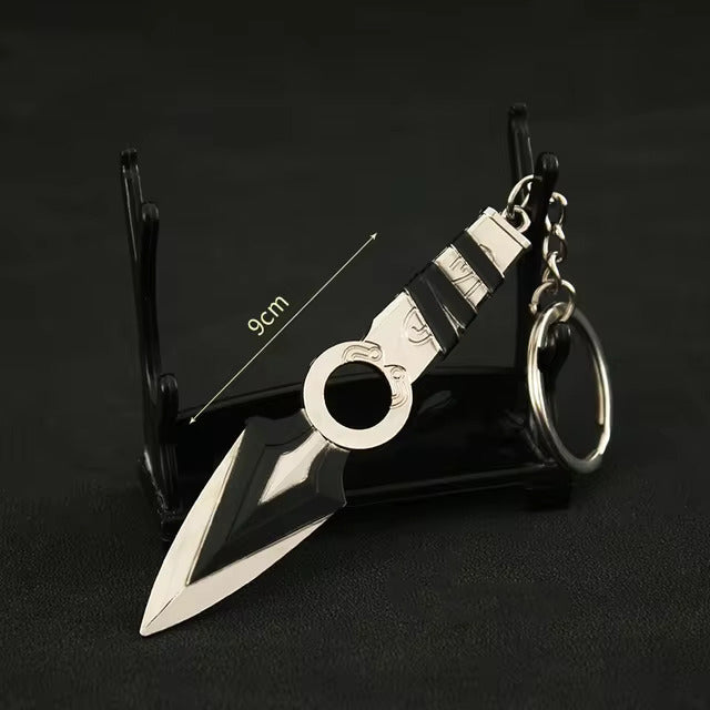 Kunai knife keychain with circular ring and striped black handle, on display