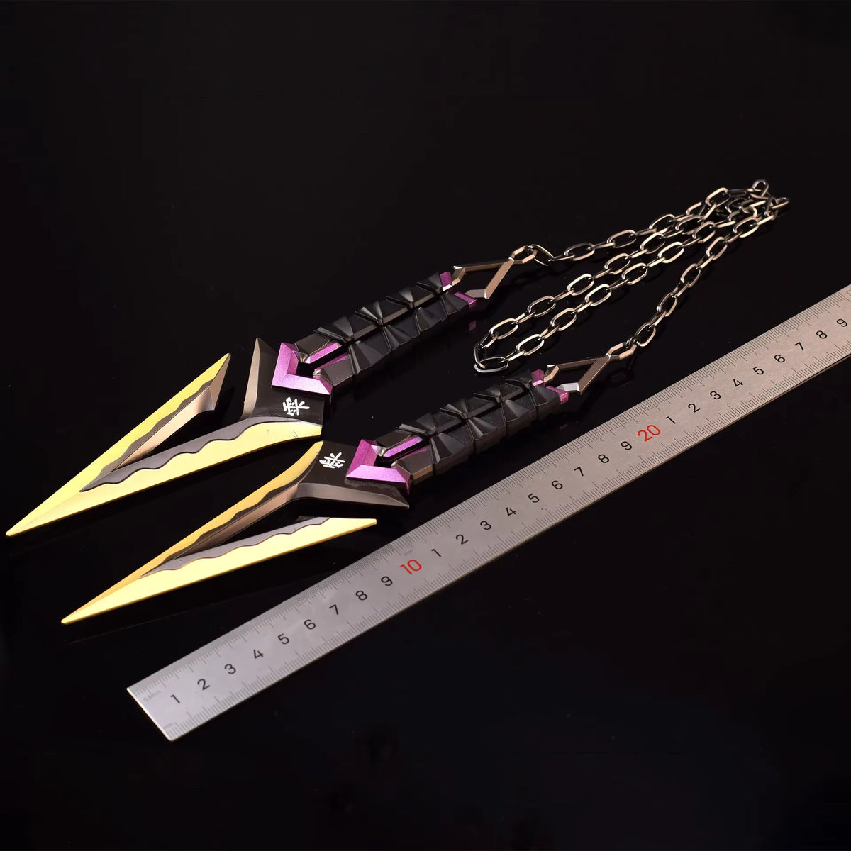 Kuronami VALORANT knife keychain beside ruler, black with purple accents and gold tips