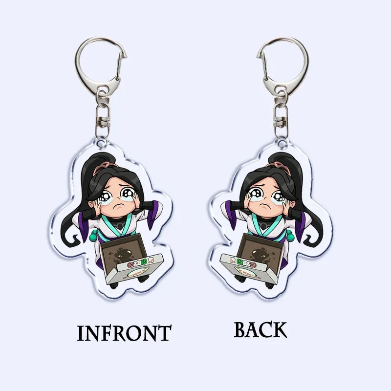 Two-sided acrylic keychain with a cartoon girl holding a game card, on a metal ring
