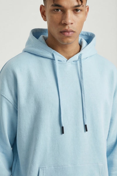 Person wearing a light blue hoodie against a plain background