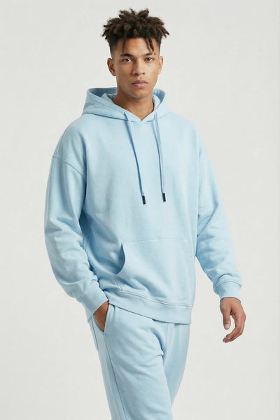 Person wearing a light blue tracksuit on a white background