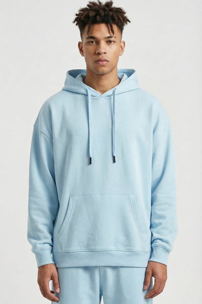 Person wearing a light blue hoodie and pants on a white background