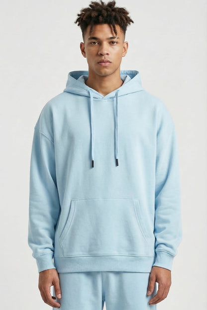 Person wearing a light blue hoodie and pants on a white background