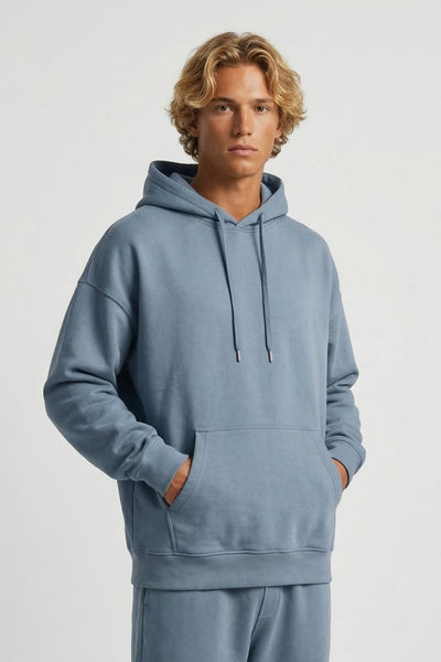 Person wearing a blue hoodie and pants on a white background