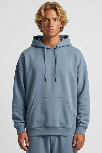 Person wearing a light blue hoodie and pants on a white background