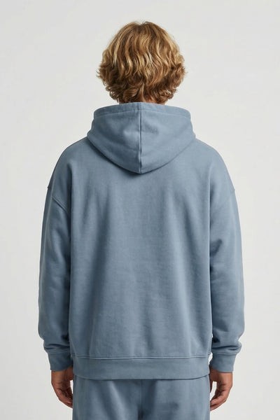 Person wearing a blue tracksuit with a plain background