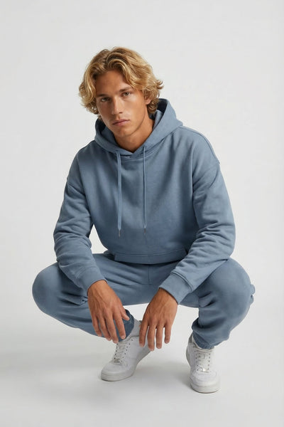 Person wearing a light blue hoodie and pants on a white background