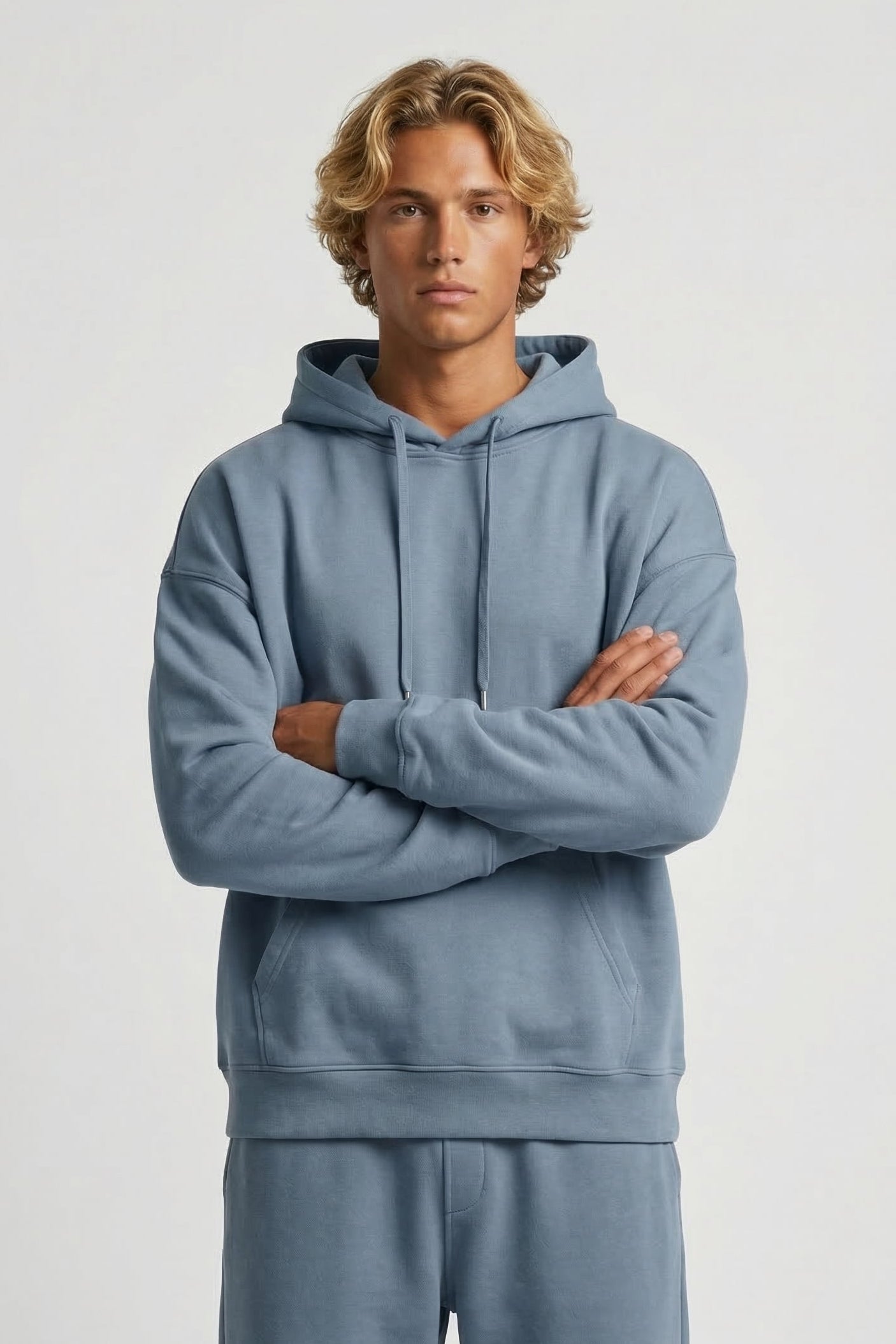 Person wearing a light blue hoodie and pants on a white background
