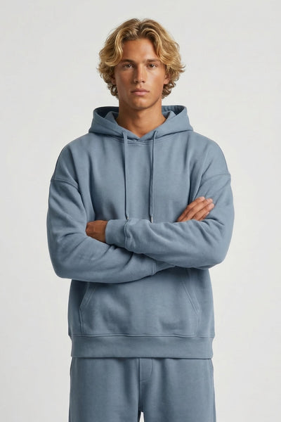 Person wearing a light blue hoodie and pants on a white background