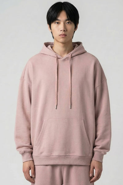 Person wearing a pink hoodie and pants on a white background