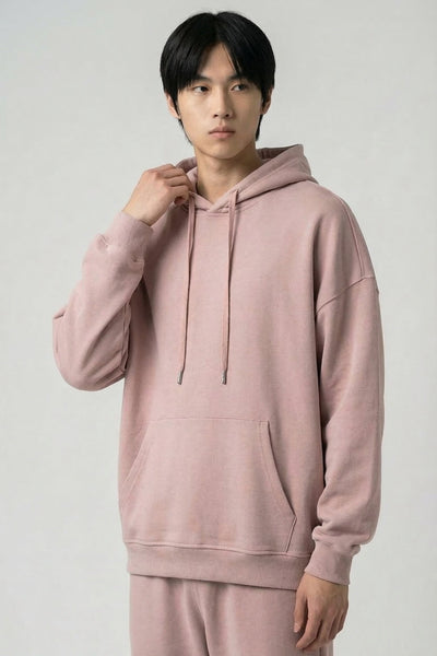 Person wearing a pink hoodie and pants on a plain background