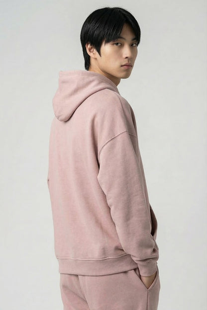 Person wearing a pink hoodie and pants on a white background