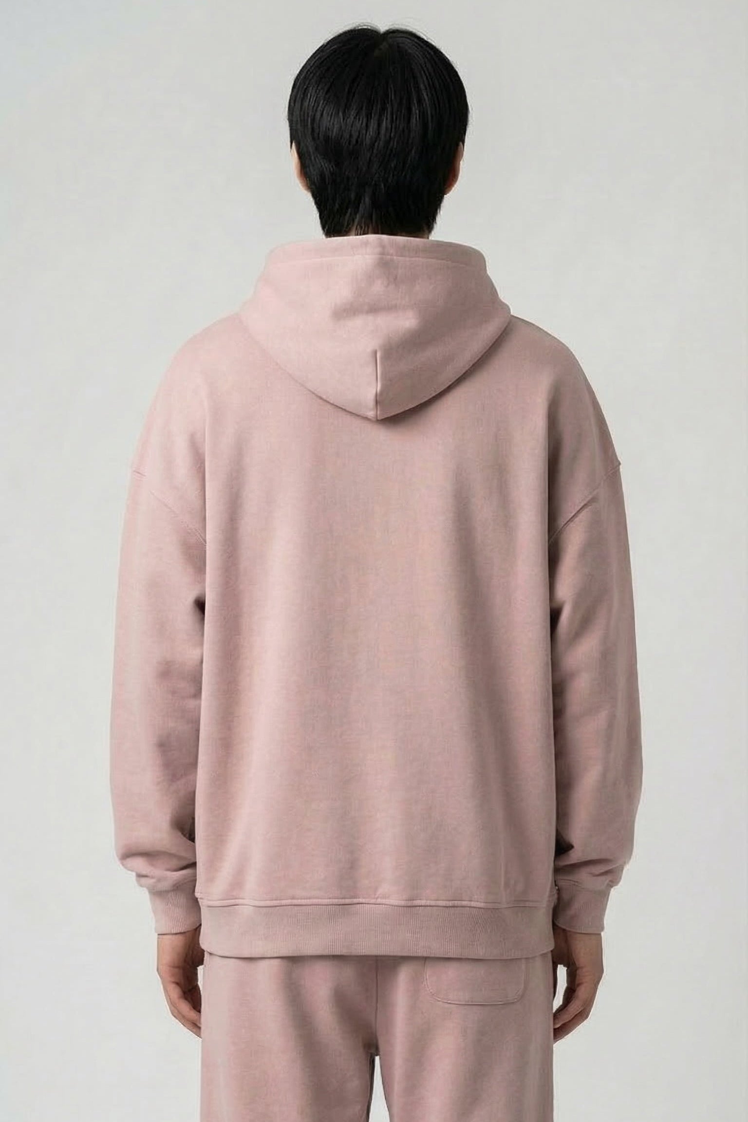 Person wearing a pink tracksuit against a plain background