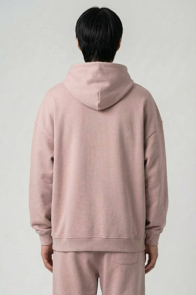 Person wearing a pink tracksuit against a plain background