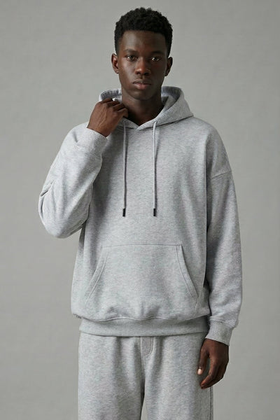 Person wearing a gray hoodie and pants on a plain background