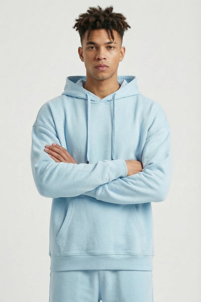 Person wearing a light blue hoodie and pants on a white background