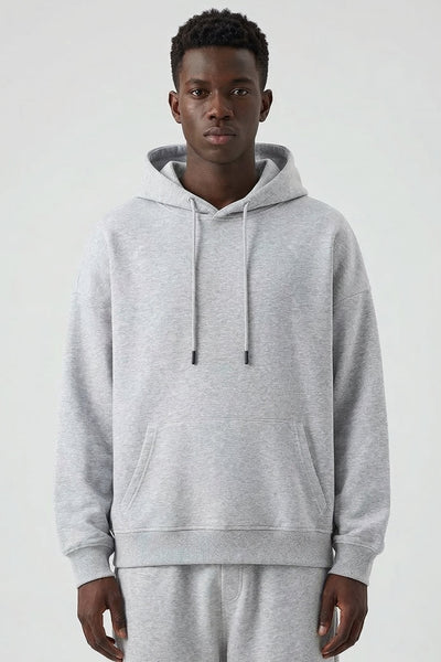 Man wearing a gray hoodie and pants on a white background