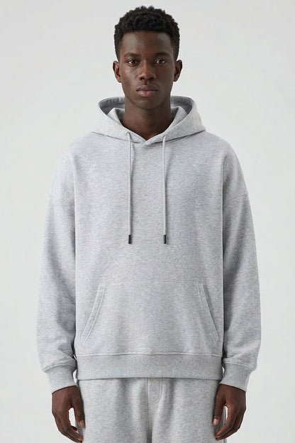 Man wearing a gray hoodie and pants on a white background