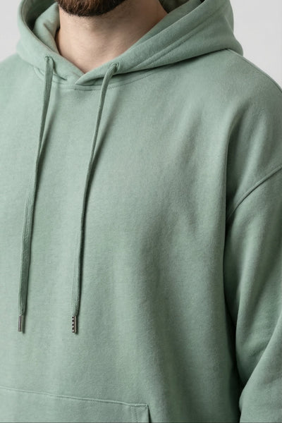 Person wearing a light green hoodie against a plain background