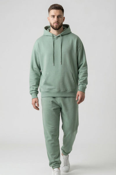 Man wearing a green hoodie and jogger set on a white background