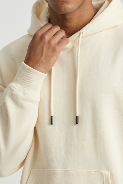 Man wearing a beige hoodie against a white background