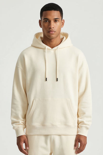 Man wearing a cream hoodie and pants on a white background