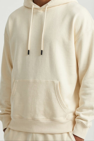Person wearing a beige hoodie on a light gray background
