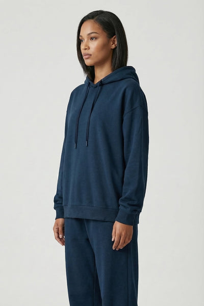 Person wearing a navy blue hoodie and pants on a white background