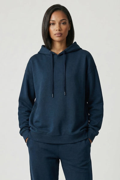 Woman wearing a navy blue hoodie and pants on a white background