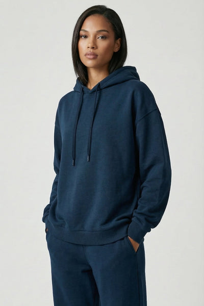 Person wearing a navy blue hoodie and pants on a white background