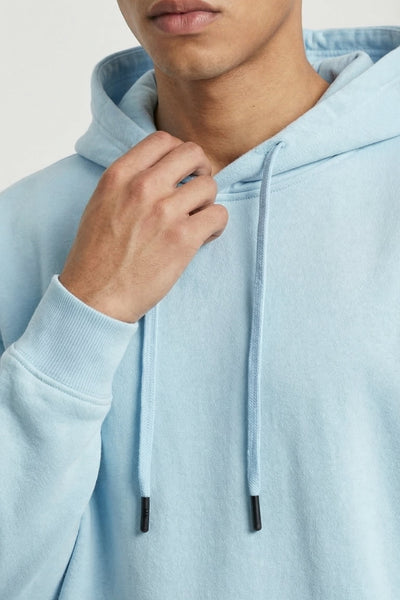 Light blue hoodie worn by a person on a plain background