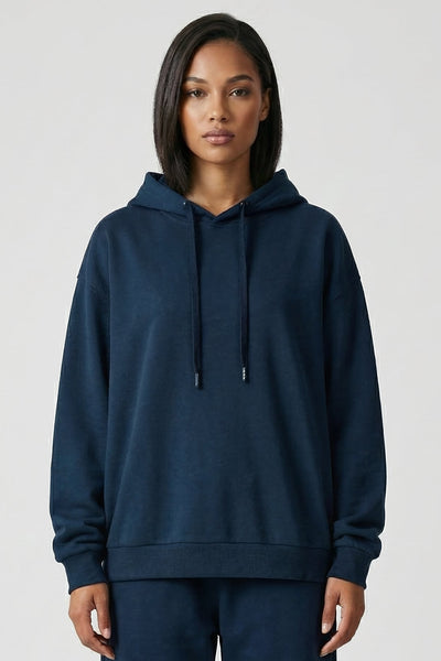 Person wearing a navy blue hoodie and pants on a white background