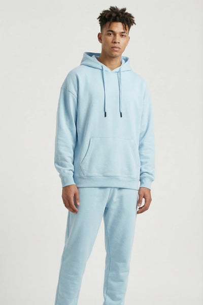 Person wearing a light blue tracksuit on a white background