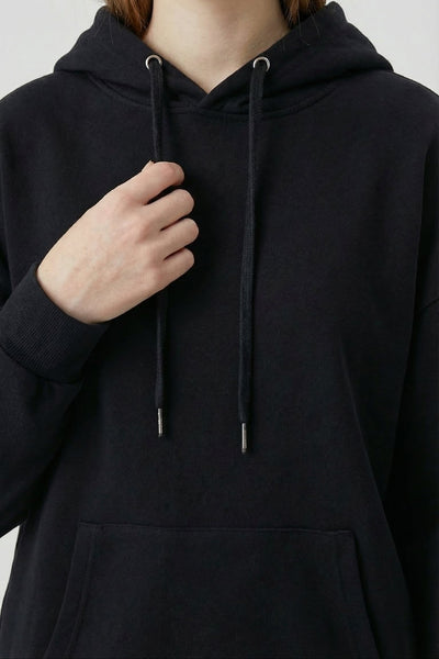 Person wearing a black hoodie with a neutral background