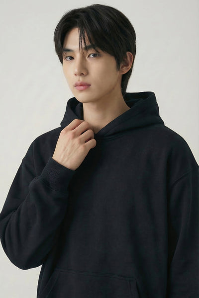 Person wearing a black hoodie against a plain background