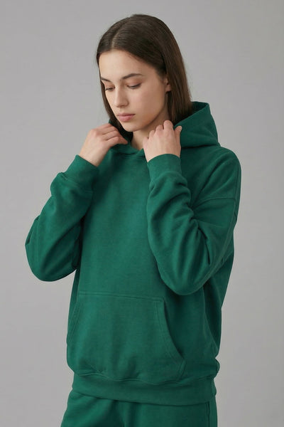 Person wearing a green tracksuit against a gray background