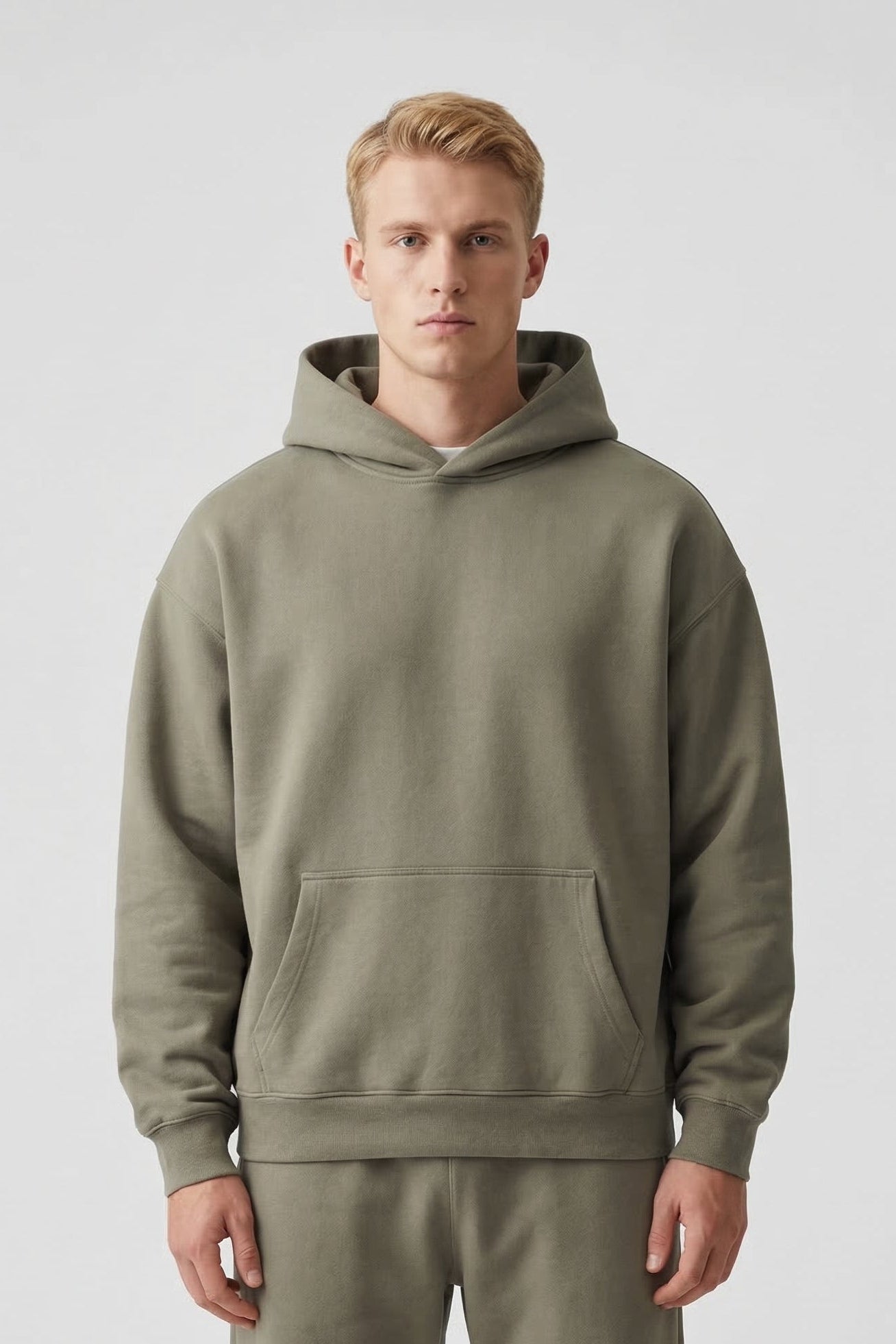 Man wearing a green hoodie and pants on a white background