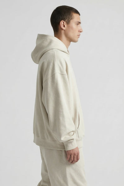 Man wearing a beige hoodie and pants on a white background