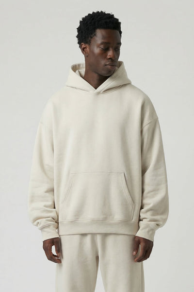 Man wearing a beige hoodie and pants set on a white background