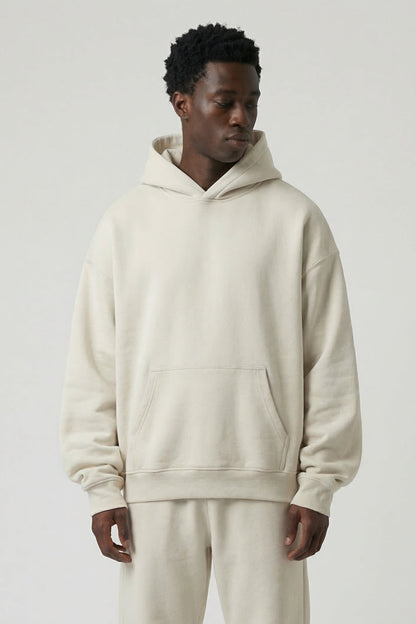 Man wearing a beige hoodie and pants set on a white background