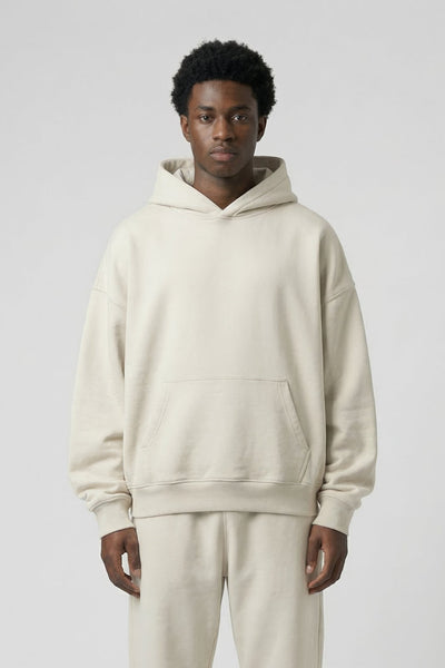 Person wearing a beige hoodie and pants on a white background