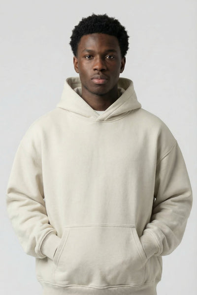 Person wearing a beige hoodie and pants on a white background