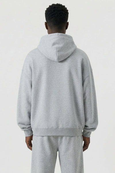 Person wearing a gray tracksuit on a white background