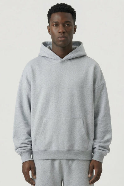 Person wearing a gray hoodie and pants on a white background