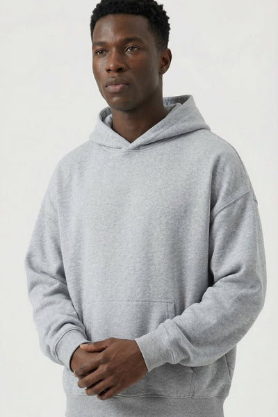 Man wearing a gray hoodie and pants on a white background